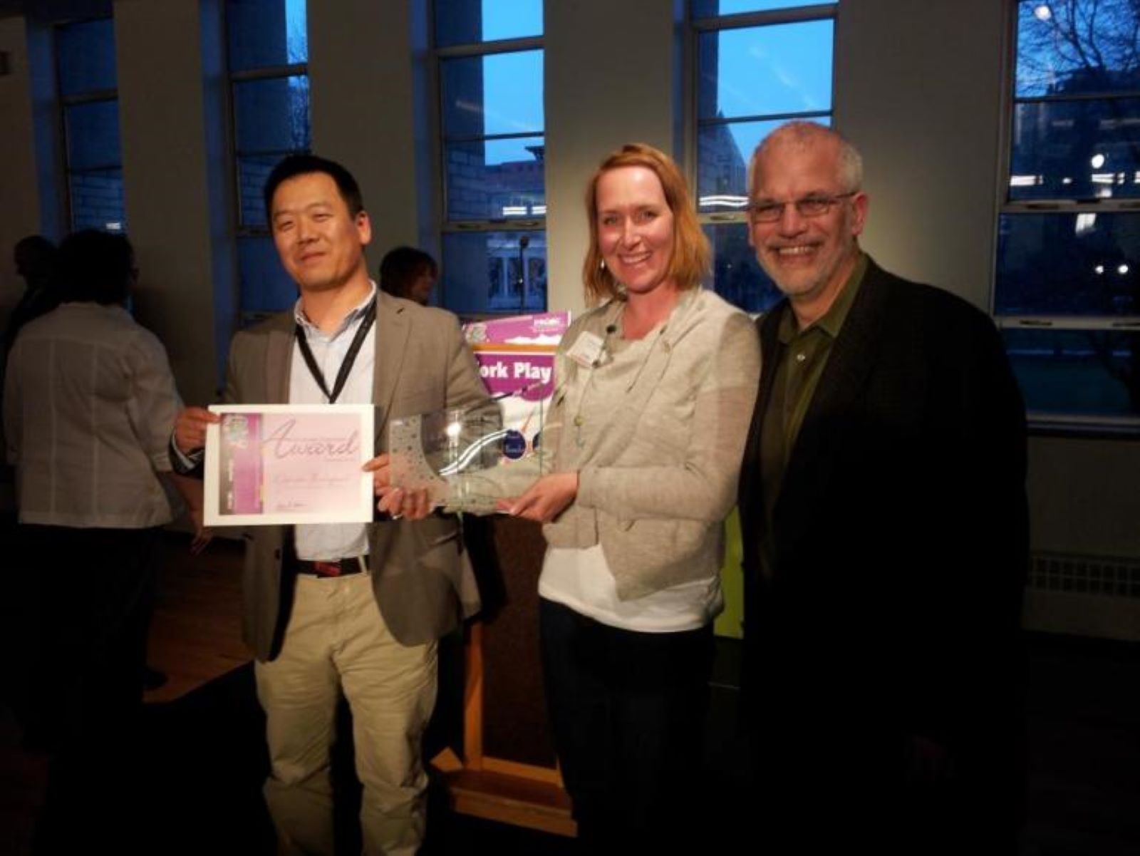 A group of three people from the Denver Zoological Foundation accepting an award from DRCOG.